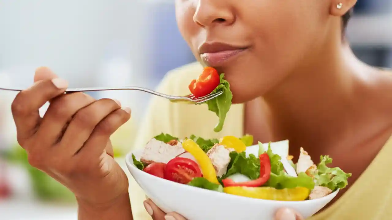 A close-up of a person thoughtfully chewing a bite of healthy, colorful food, emphasizing the importance of thorough mastication for digestive health.