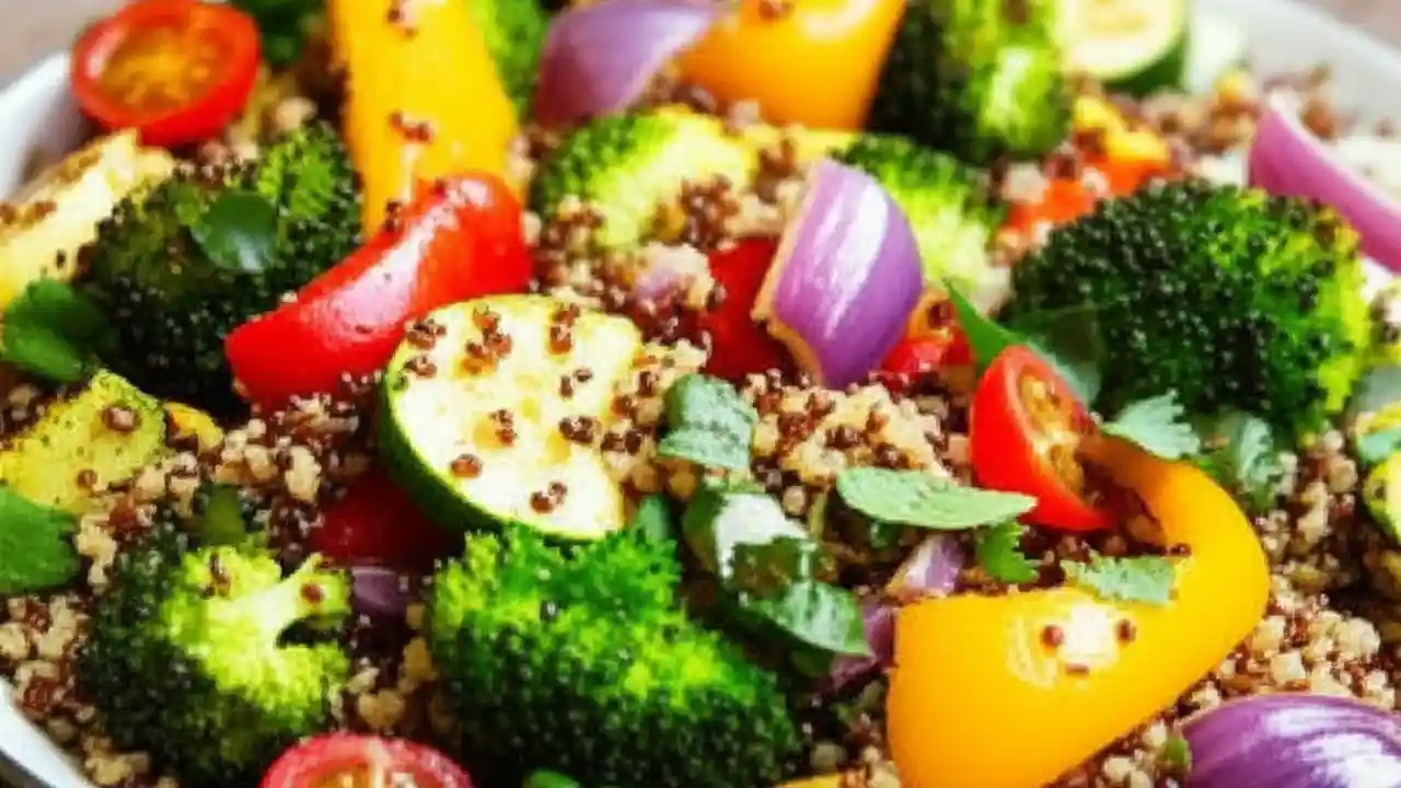 A colorful Quinoa Salad with Roasted Vegetables in a large bowl, featuring caramelized bell peppers, broccoli, zucchini, and red onion.